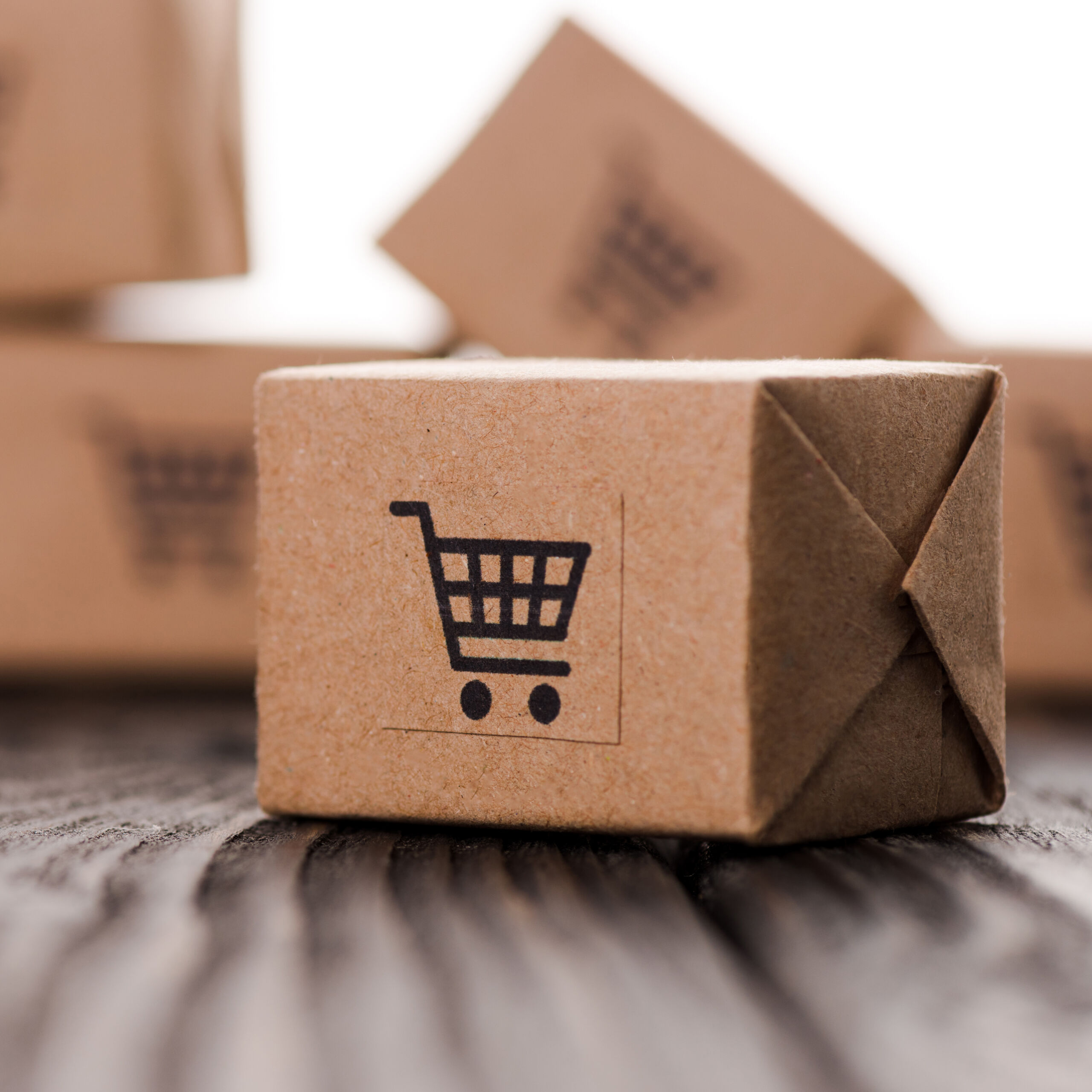 Close up of small carton boxes on table isolated on white, e commerce concept